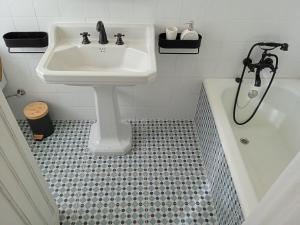 een badkamer met een wastafel en een bad bij Piso Iwvaxi, gallery house. Ourense. in Ourense