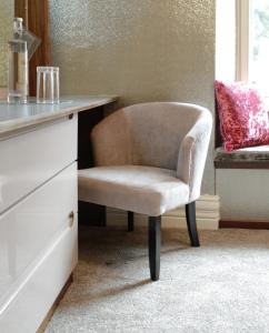 a chair sitting next to a desk in a room at The Cranleigh Boutique in Bowness-on-Windermere