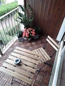 a wooden bench sitting on a balcony with flowers at GRAND Appart 46m² en ville à 10 mn de la plage in Cabourg