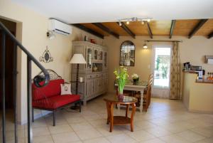 a living room with a red chair and a table at Villa de 2 chambres avec piscine partagee jardin clos et wifi a Grillon in Grillon