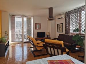 a living room with a couch and chairs and a television at Risto Apartment in Skopje