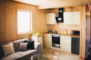 a living room with a couch and a kitchen at Jantar Domki Comfort oraz Comfort Wellness Zone sauna jacuzzi in Jantar