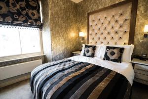 a bedroom with a large bed and a large window at The Cranleigh Boutique in Bowness-on-Windermere