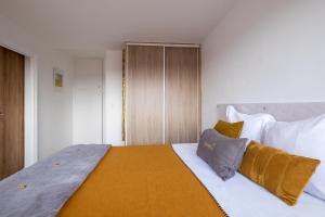 1 dormitorio con 1 cama grande con sábanas blancas y almohadas amarillas en HONORÊ SUITE SAINT ANTOINE en Lyon