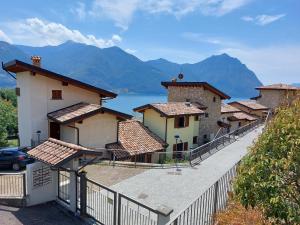 a row of buildings with mountains in the background at Iseo Lake Villa con vista lago e piscina in Costa Volpino