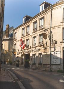 a building on the side of a street at Hôtel De La Banniere De France in Laon