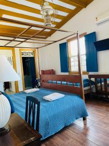 a bedroom with two beds and a table with a lamp at Suítes Casa da Colônia in Paraty