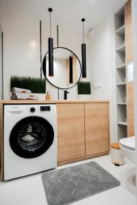 a bathroom with a washing machine and a mirror at Silvia Apartment Gliwice Karolinki 78 in Gliwice