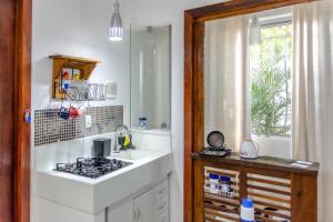 uma cozinha com um fogão, um lavatório e uma janela em Praia de Geribá 100m - loft no corredor de acesso a praia em Búzios