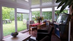 a screened in porch with a table and chairs at B&B Piccardie in Emlichheim