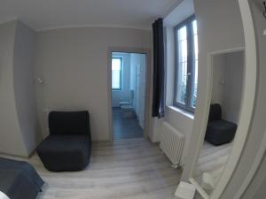 um quarto com um espelho e uma cadeira e um corredor em b&b la fabbrica em Gaglianico