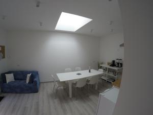 uma sala de estar com uma mesa branca e um sofá azul em b&b la fabbrica em Gaglianico