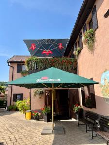 Restaurace a penzion Na Růžku في Mořina: مظلة خضراء أمام المبنى