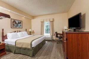 a hotel room with a bed and a flat screen tv at Baymont by Wyndham Columbia Maury in Columbia