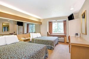 ein Hotelzimmer mit 2 Betten und einem Fenster in der Unterkunft Days Inn by Wyndham Sturbridge in Sturbridge