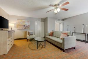 a living room with a couch and a ceiling fan at Best Western Pecos Inn in Artesia