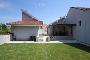 a house with a grass yard in front of it at Relax Apartmani Rooms in Kladovo