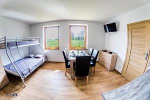 a room with a dining table and a bunk bed at Apartamenty Tilia Laskowa - Zator in Laskowa