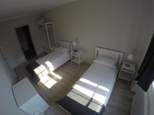 Duas camas num quarto com luz solar a brilhar através da janela em b&b la fabbrica em Gaglianico