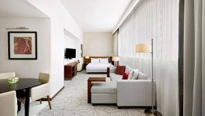 a hotel room with a bed and a living room at Hyatt Place Dubai Al Rigga in Dubai