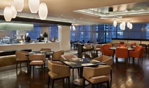 a restaurant with tables and chairs and a bar at Hyatt Place Dubai Al Rigga in Dubai