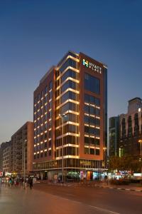 een hoog gebouw met een bord aan de zijkant bij Hyatt Place Dubai Baniyas Square in Dubai