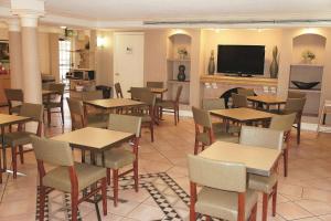 a restaurant with tables and chairs and a flat screen tv at Days Inn by Wyndham Augusta Washington Rd in Augusta