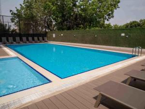 a swimming pool with blue water and a wooden deck at Amazing One Bedroom Apartment Space Available in Accra