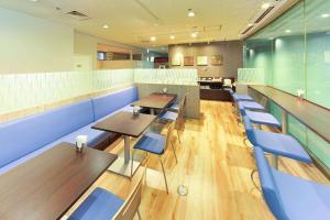 大阪市にあるベストウェスタン大阪塚本の木製テーブルと青い椅子が備わるレストラン