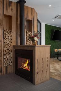 a fireplace in a room with a pile of logs at Rydges South Park Adelaide in Adelaide