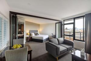 a hotel room with a bed and a couch and a table at Rydges South Park Adelaide in Adelaide