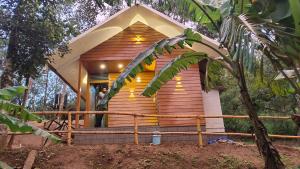 a man standing in the front of a tree house at Mountainmist wooden cottages in Ramakkalmedu