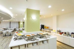 uma cozinha com várias bandejas de comida num balcão em SureStay Plus Hotel by Best Western Shin-Osaka em Osaka