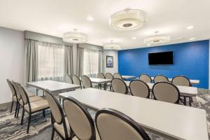uma sala de conferências com mesas e cadeiras e uma televisão de ecrã plano em Best Western Plus Magnolia Inn & Suites em Cleveland