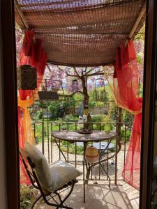un patio con mesa, sillas y un árbol en LA MAISON D'IVONA, en La Tour-de-Salvagny