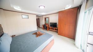 a bedroom with a large bed with a wooden cabinet at Shiba Guesthouse in Pattaya South