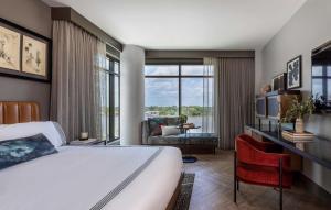 a hotel room with a bed and a large window at Thompson Savannah, by Hyatt in Savannah