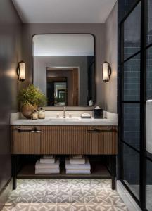 a bathroom with a sink and a mirror at Thompson Savannah, by Hyatt in Savannah