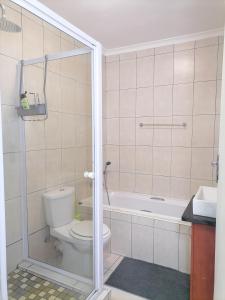 ein Badezimmer mit einem WC und einer Badewanne in der Unterkunft Muizenberg Mountain View Apartment in Kapstadt