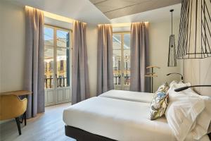 a hotel room with a bed and windows at Vincci Larios Diez in Málaga +41 photos