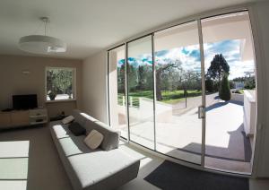 uma sala de estar com um sofá e uma grande janela em Salento- Villa Torricella em Leverano