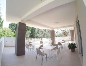 eine Terrasse mit Tischen und Stühlen auf dem Balkon in der Unterkunft Salento- Villa Torricella in Leverano