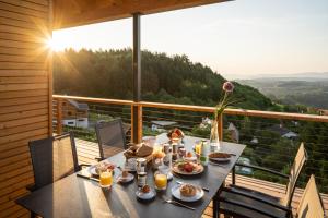 einen Tisch mit Speisen auf dem Balkon mit Aussicht in der Unterkunft steiRerBLiCke - Domizil Vochera am Weinberg mit Pool 