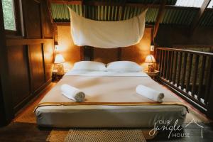 a bed in a room with two lamps at Our Jungle House in Khao Sok National Park