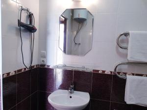 La salle de bains est pourvue d'un lavabo et d'un miroir. dans l'établissement Plaza Apartments, à Bishkek