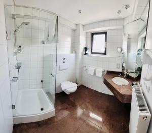 uma casa de banho com um WC e um lavatório. em CityHotel Hessischer Hof em Fulda
