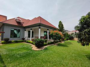 una casa con un patio con césped verde en Villa Kikiriki en Kigali