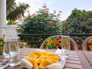 a table with a plate of orange slices on it at Villa Kikiriki in Kigali