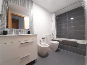 uma casa de banho com um WC, um lavatório e uma banheira em Blaumar em Piles