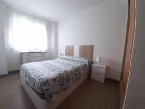 um quarto branco com uma cama e uma janela em Blaumar em Piles